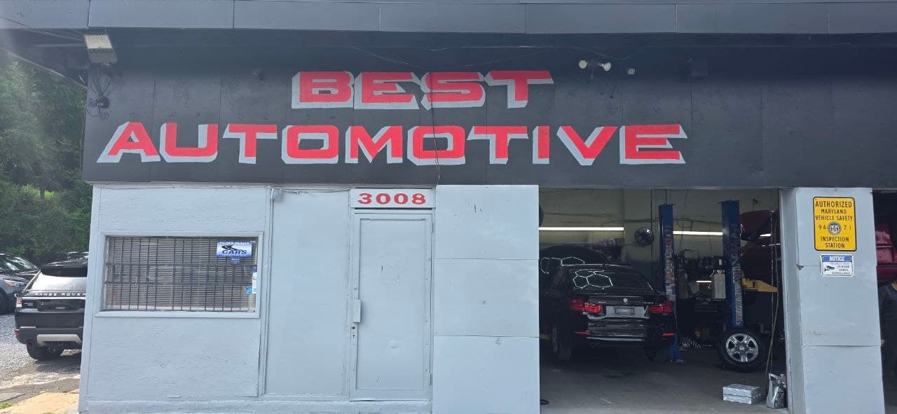 Best Automotive storefront on Wilkens Avenue with the authorized Maryland vehicle safety inspection station sign beside the open service bay